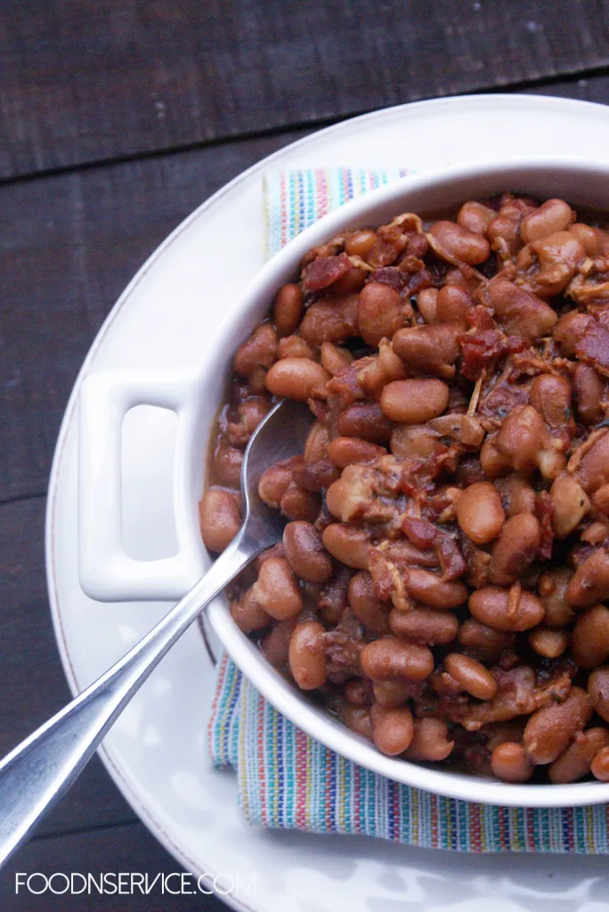 Bowl of Instant Pot pinto beans with bacon on a white plate