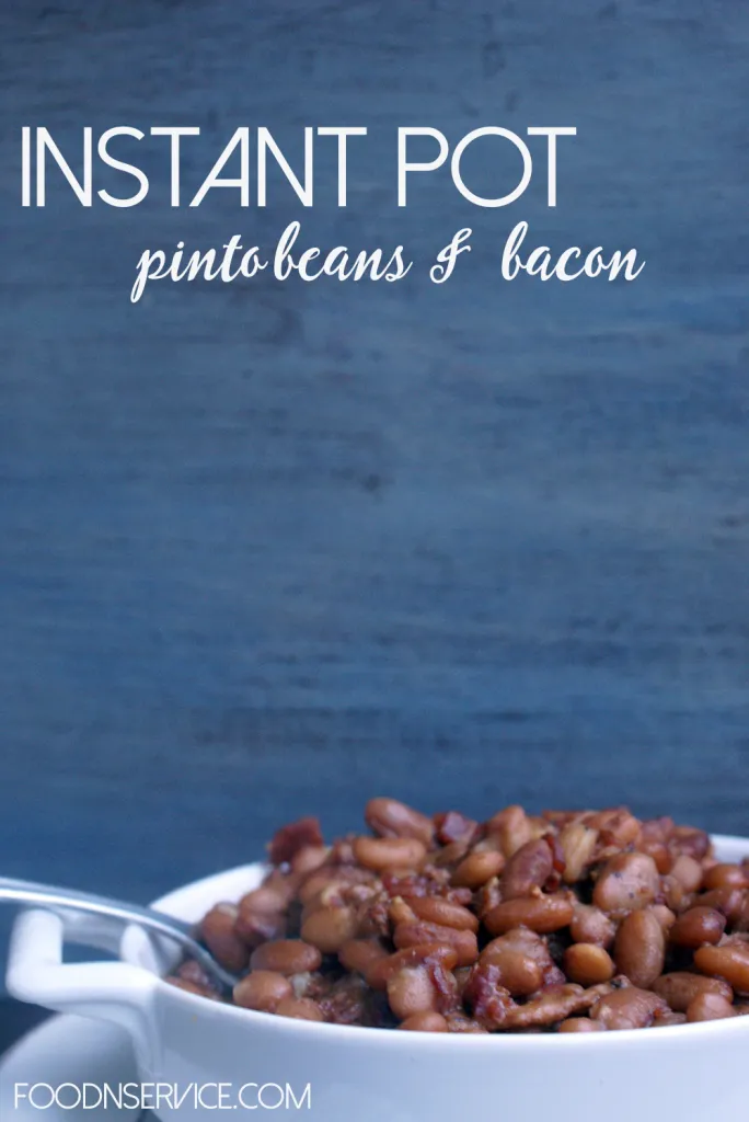 Spoon lifting creamy pinto beans from a white bowl made with an Instant Pot