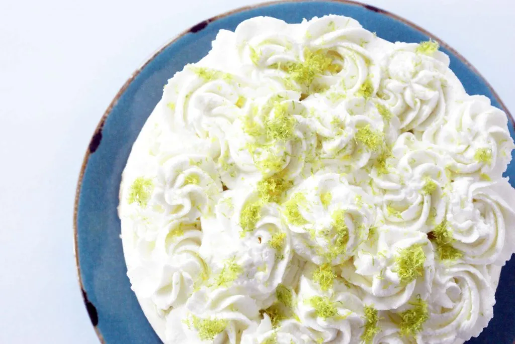 lime cheesecake with whipped cream swirls and lime zest on top