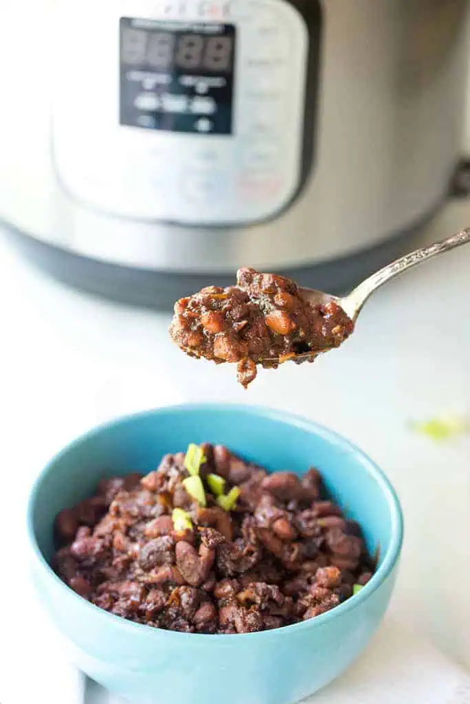 instant pot baked beans shown on a spoon