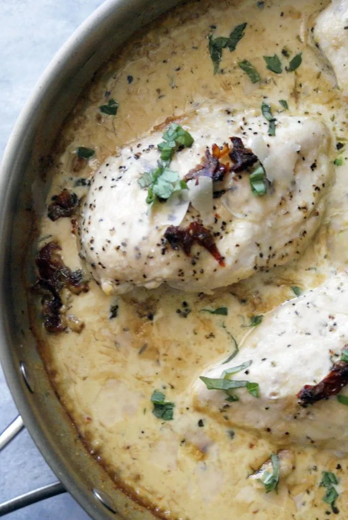 Close-up of marry me chicken with basil garnish in an oven safe skillet