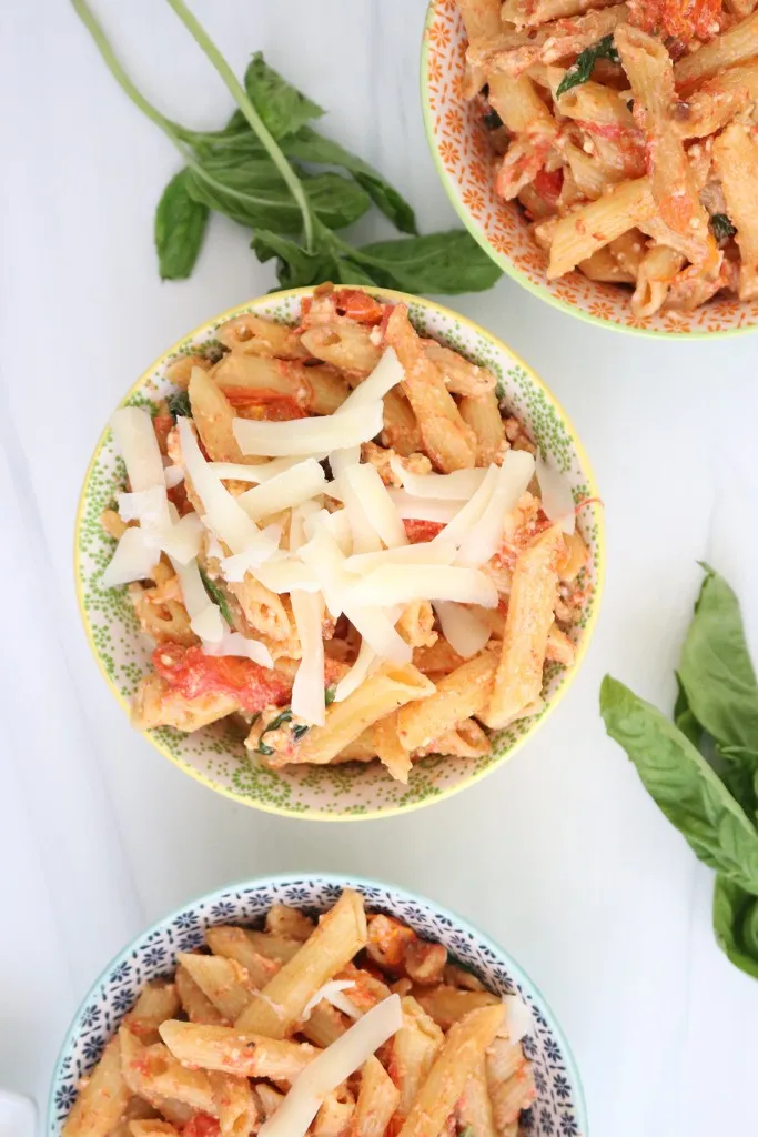 3 bowls full of feta pasta cooked in instant pot with fresh basil in background