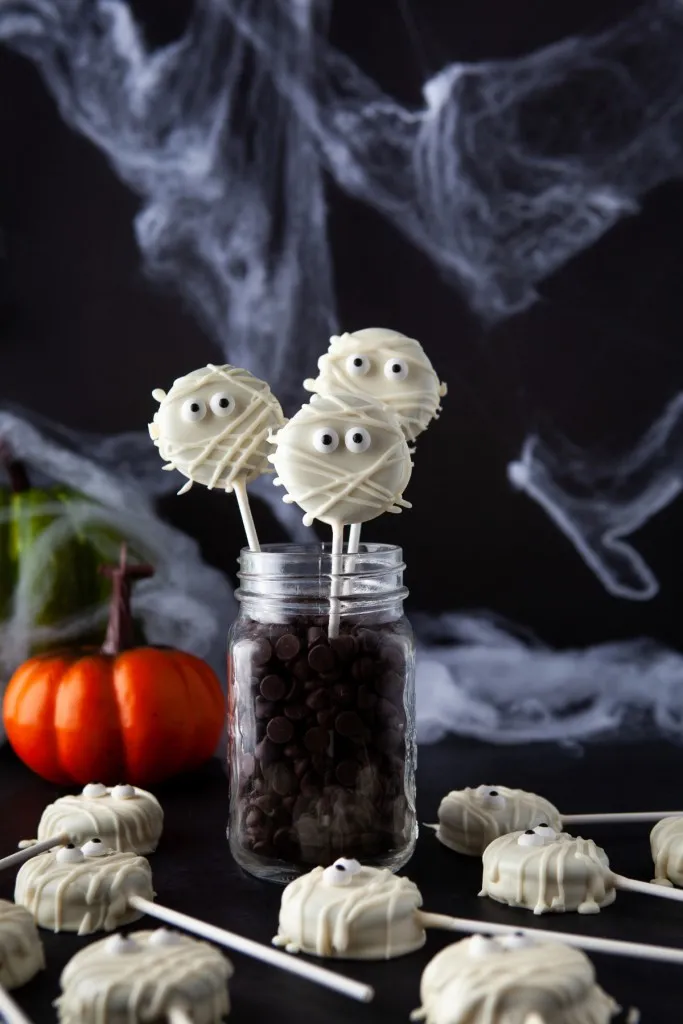 mummy pops in a jar of chocolate chips with spider webs in the background