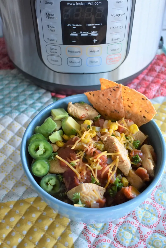 instant pot southwest chicken soup in a bowl with tortilla chips and freshly sliced jalapeño peppers