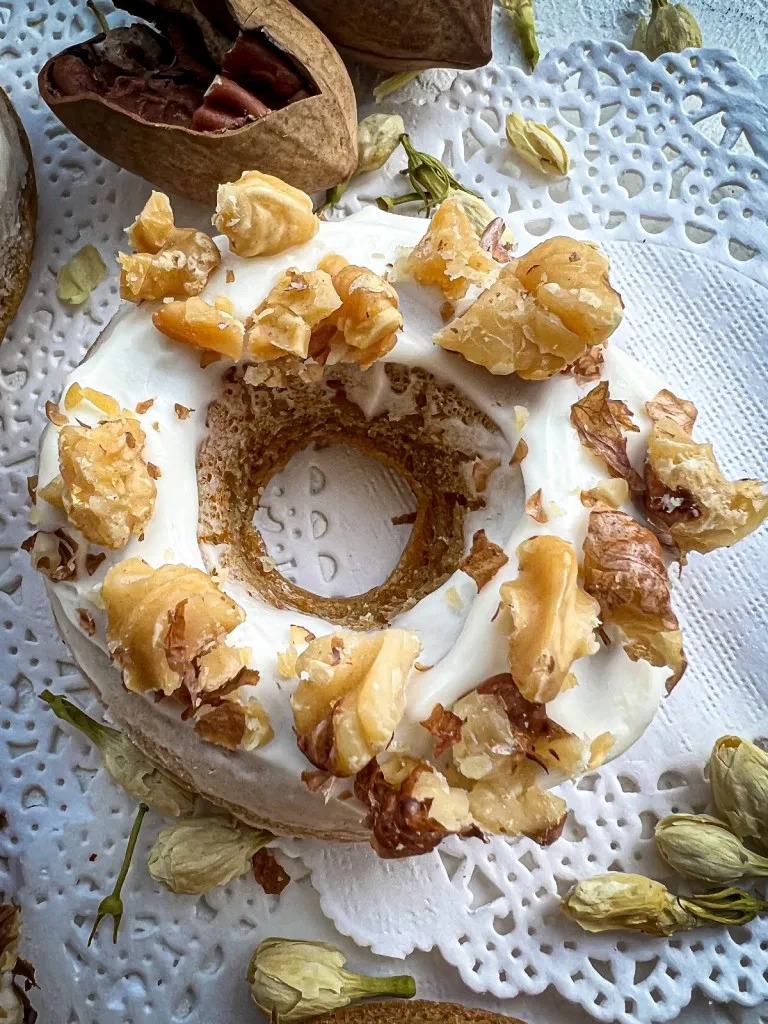 one baked carrot cake donut with diced walnuts