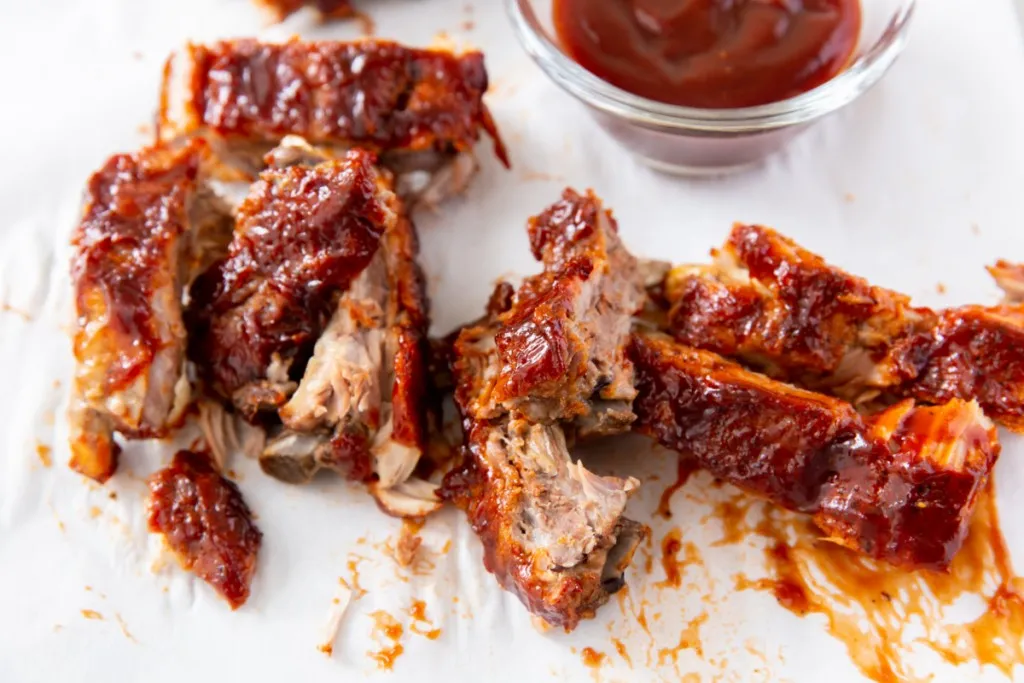 cut up baby back ribs on a cutting board