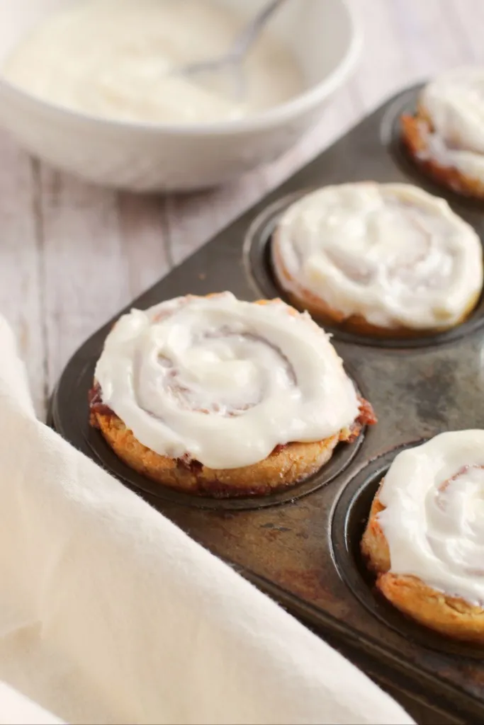 glazed cinnamon rolls in a muffin tin