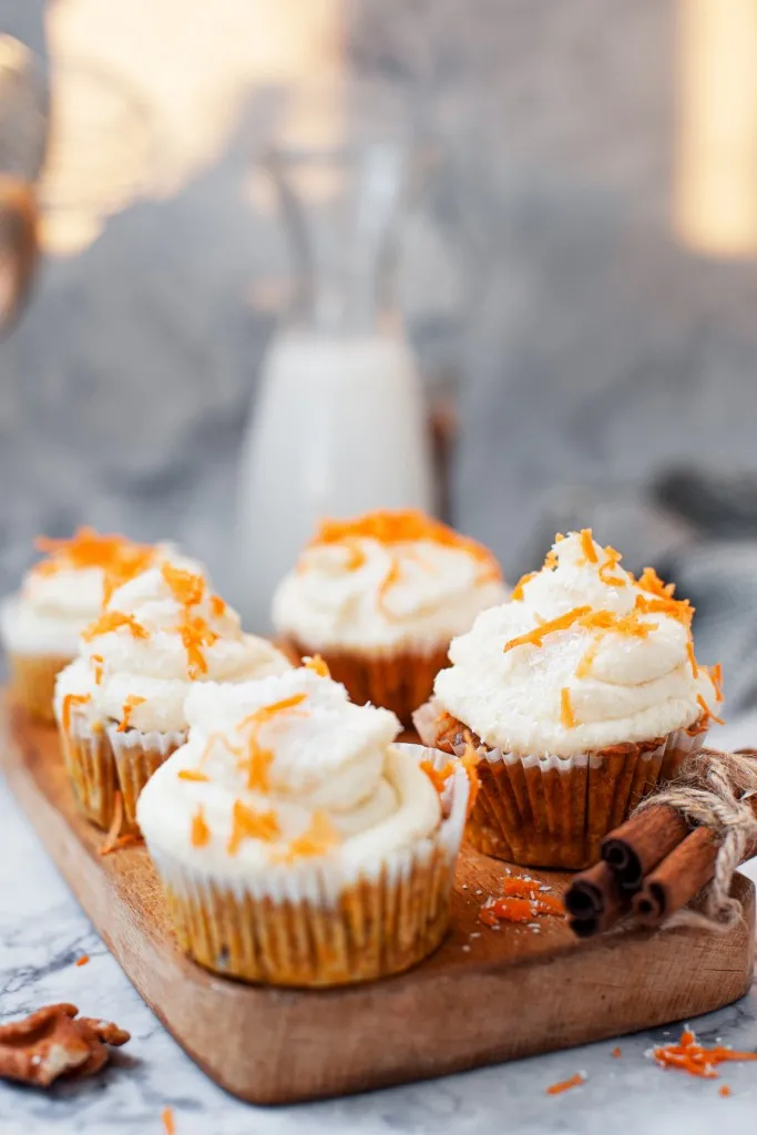 side view of cupcakes on a wooden board with cinnamon sticks