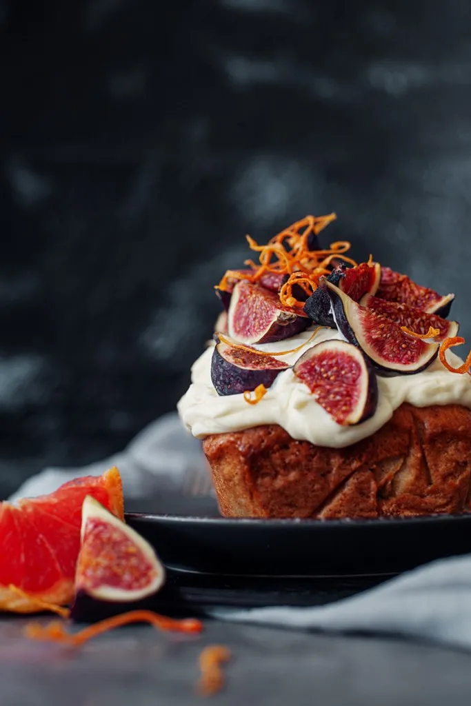 side view of fig loaf cake on a dark grey plate