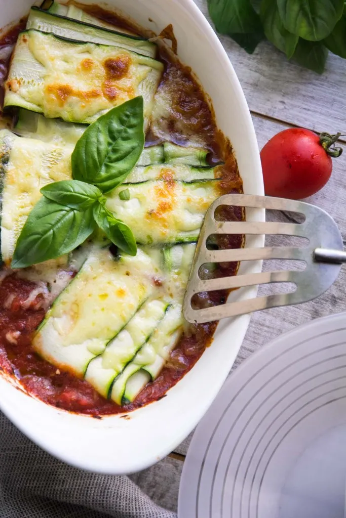 baked dish with zucchini and cheese topped with basil