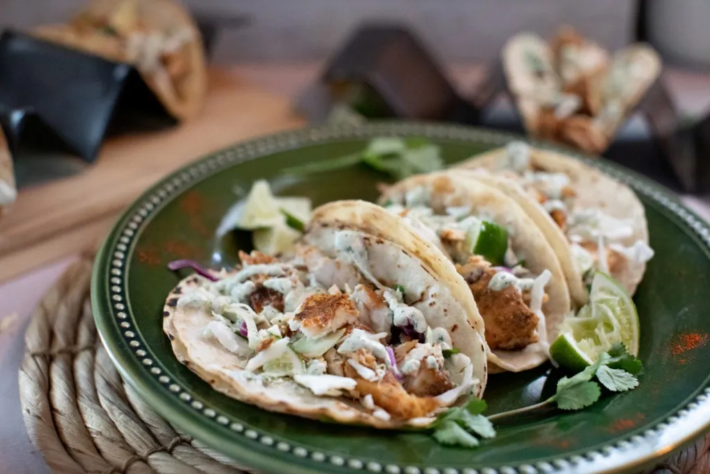 3 blackened mahi mahi fish tacos on a green plate