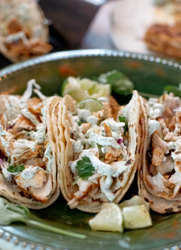 side view of 3 blackened mahi mahi fish tacos and lime wedges