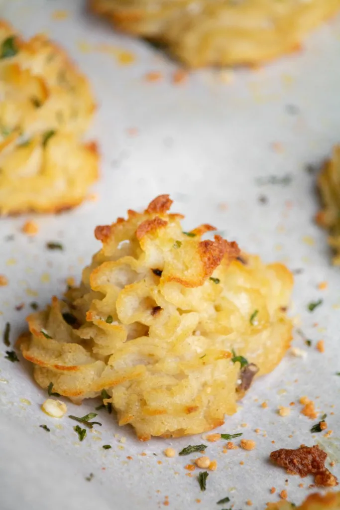 crispy baked duchess potatoes recipe on parchment paper and fresh herbs