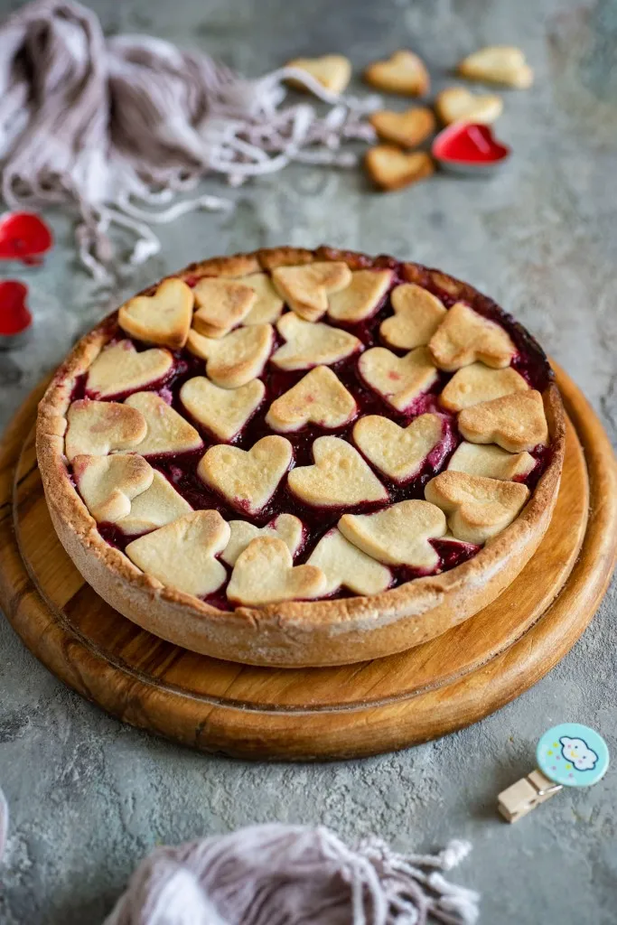 whole cherry tart on a round wooden cutting board