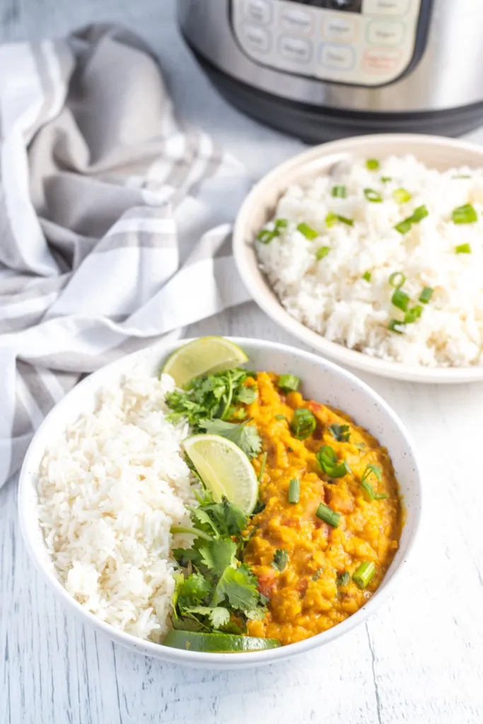 overhead shot of instant pot lentil curry in a white bowl with rice