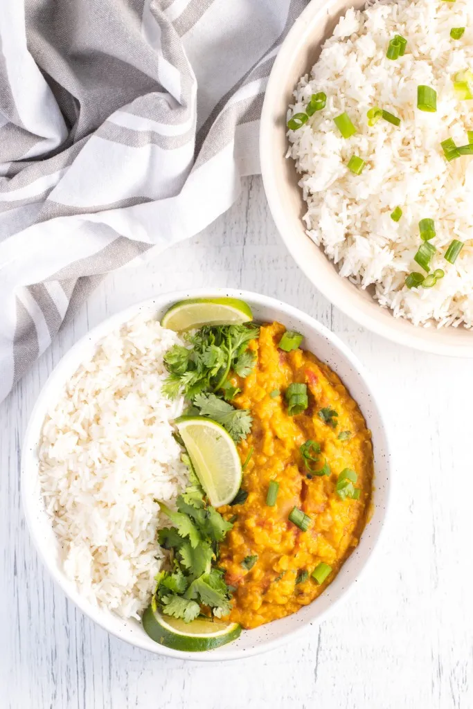 fresh lime and cilantro in a bowl of instant pot lentil curry and rice
