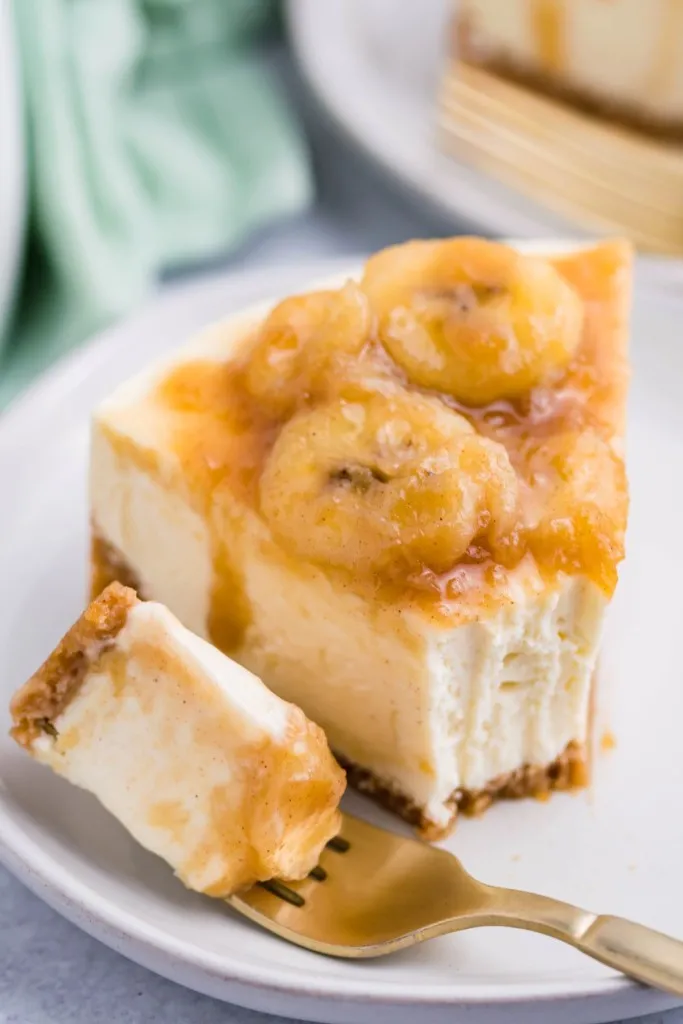 fork and plate of instant pot cheesecake with a bananas foster sauce on top