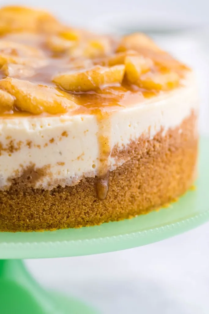 sideview of bananas foster topping on an instant pot cheesecake on a green platter