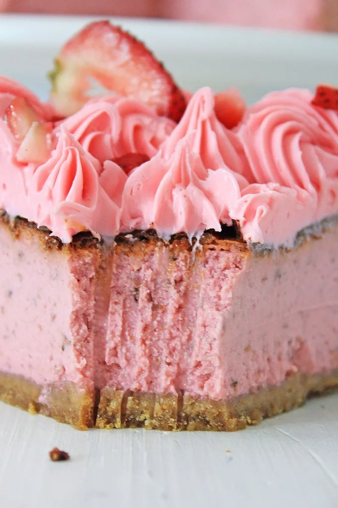 a close up view of air fryer strawberry cheesecake with a fork full missing