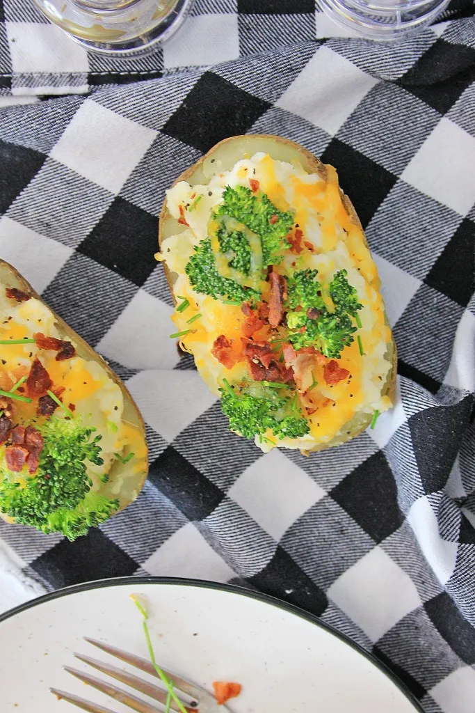 2 halves of instant pot loaded baked potatoes on a black and white checkered napkin
