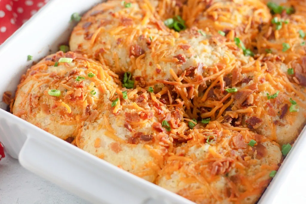 close up shot of crumbled bacon and cheddar on these pillsbury biscuits