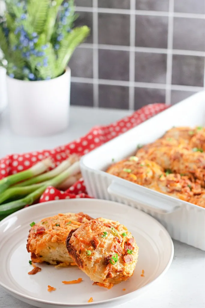 side view shot of bacon cheddar ranch biscuits on a white plate