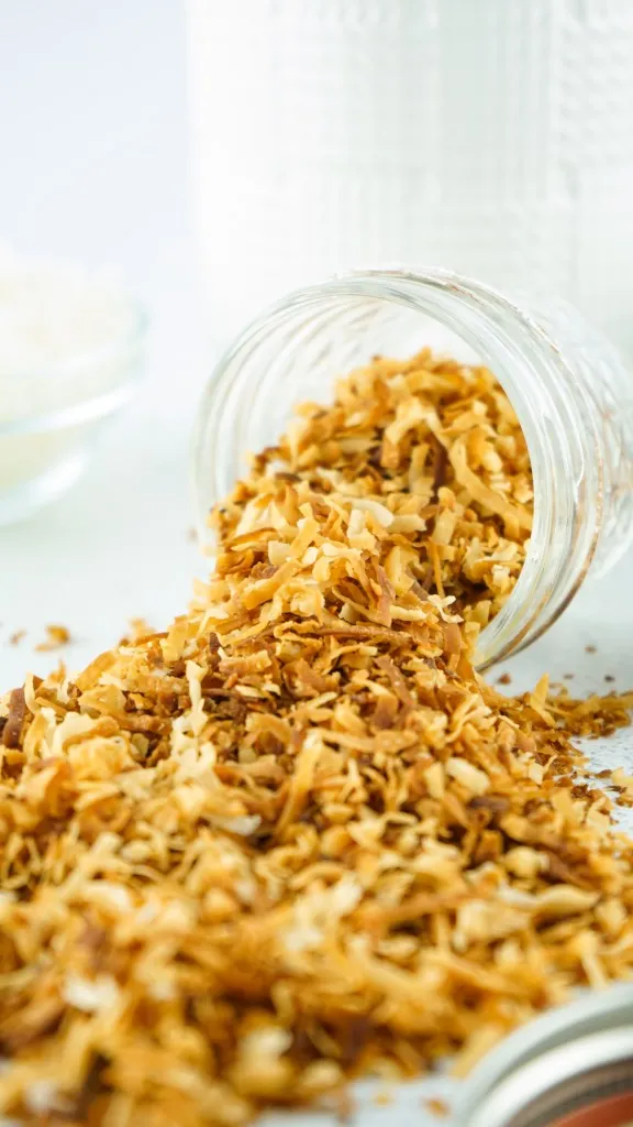 toasted coconut spilled out of a jar and onto a table