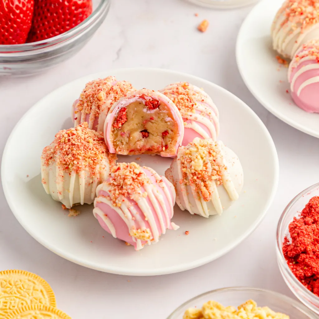 strawberry crunch cake balls drizzled in white chocolate and covered in strawberry crunch