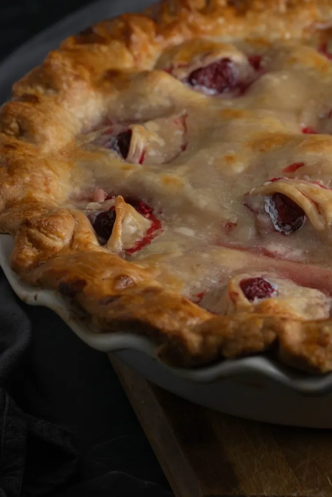 Close up of Eyeball Pie in a pie dish, decorated with spooky cherry eyeballs and pastry eyelids.