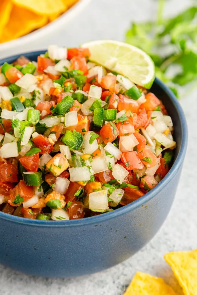 Close up of Pico de Gallo, bowl of tortilla chips.