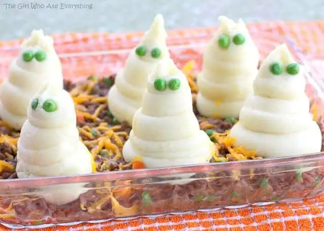 mounds of mashed potatoes that look like ghosts with green pea eyes