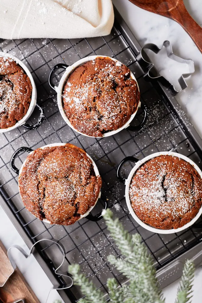 Overhead view of gingerbread pudding cakes on a wire rack.