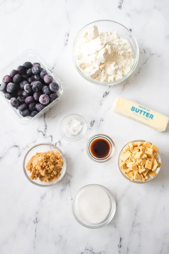 Ingredients for blueberry white chocolate cookies on a marble countertop.