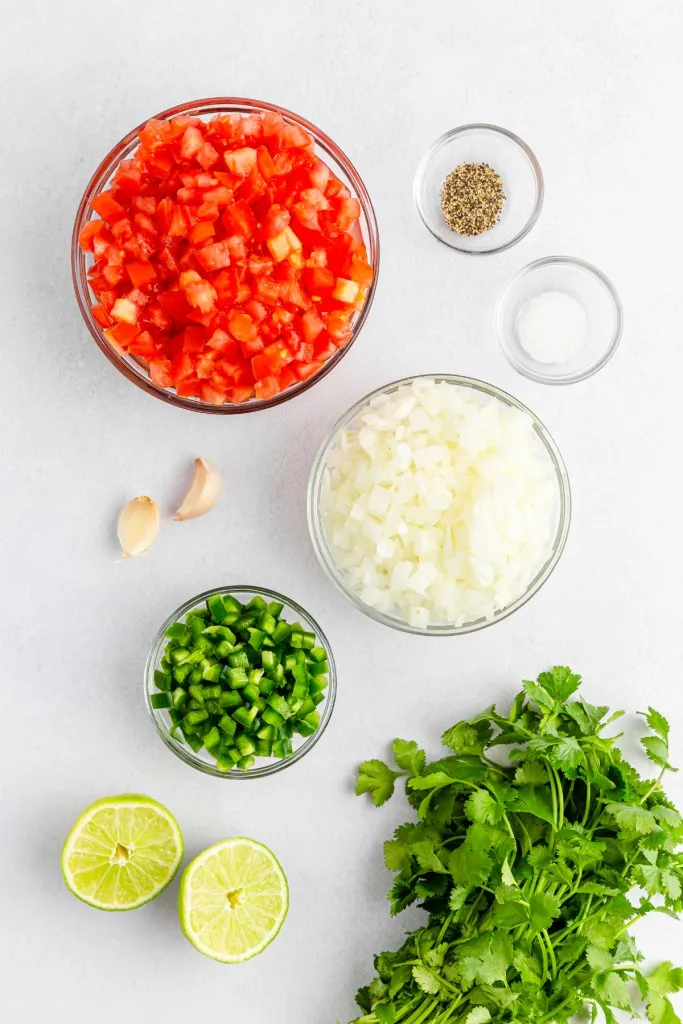 Pico De Gallo Recipe ingredients on a white countertop.