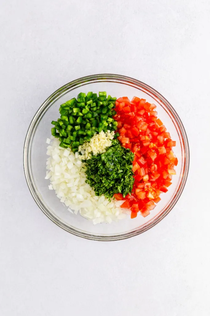 Pico de Gallo ingredients added to a mixing bowl.