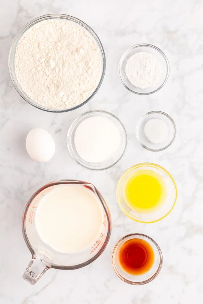 Ingredients for mini pancakes recipe on a marble countertop.