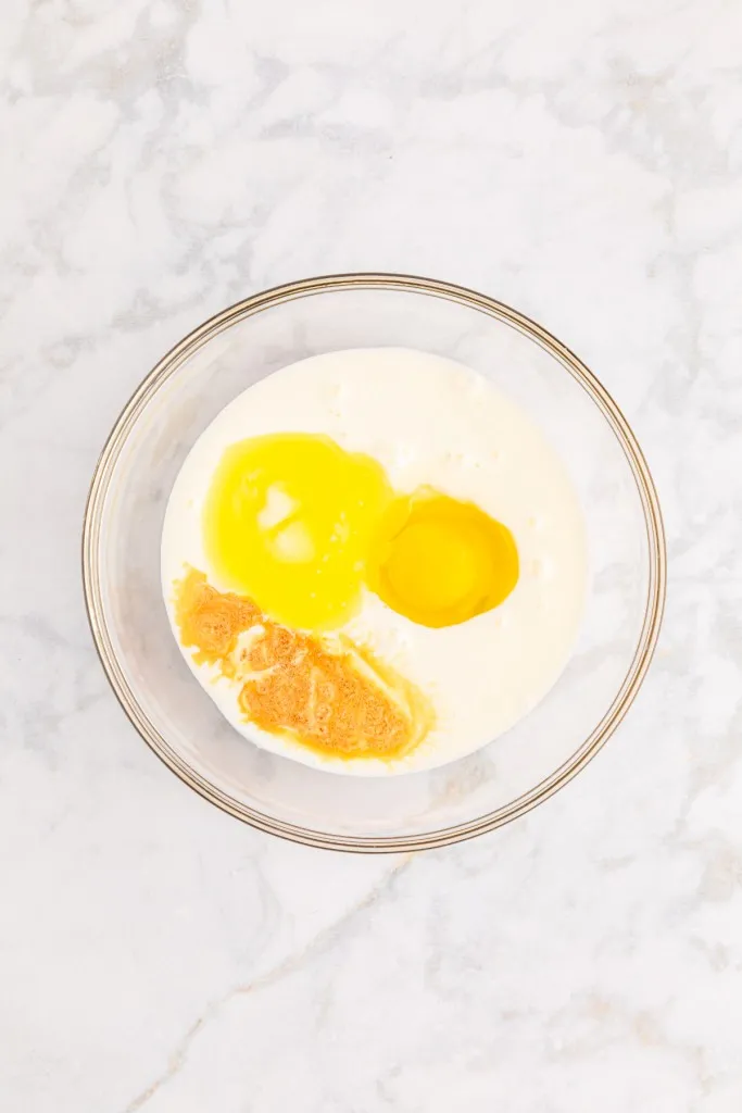 Mixing bowl with melted butter, buttermilk, vanilla extract, and egg.