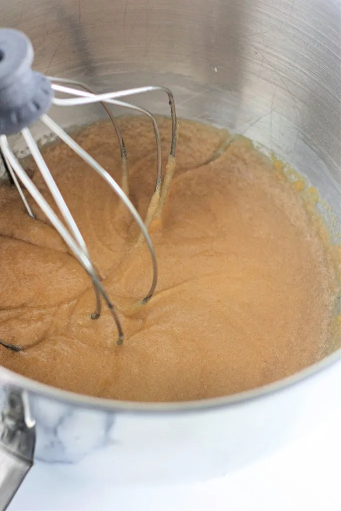 Bowl of a stand mixer with combined wet ingredients for cosmic brownie cookies.