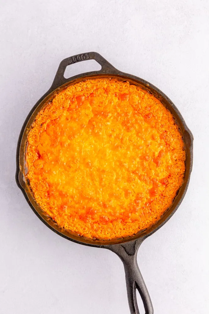 Baked buffalo chicken dip in a cast iron skillet.