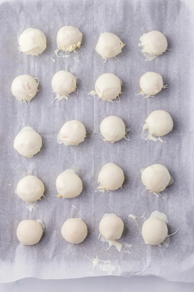 Parchment-lined tray loaded with chocolate-coated truffles.