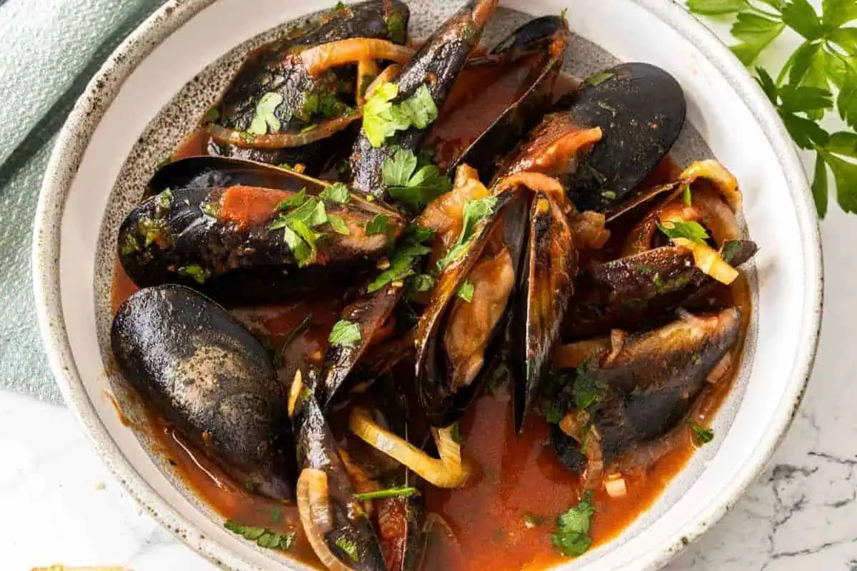 Steamed mussels with sauce in a bowl.