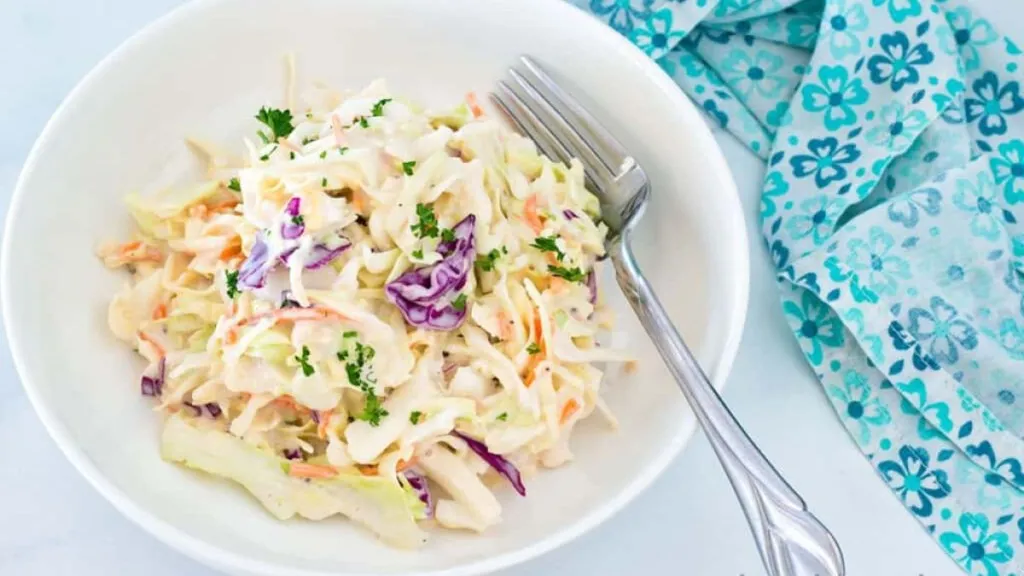 A bowl of coleslaw with a fork.