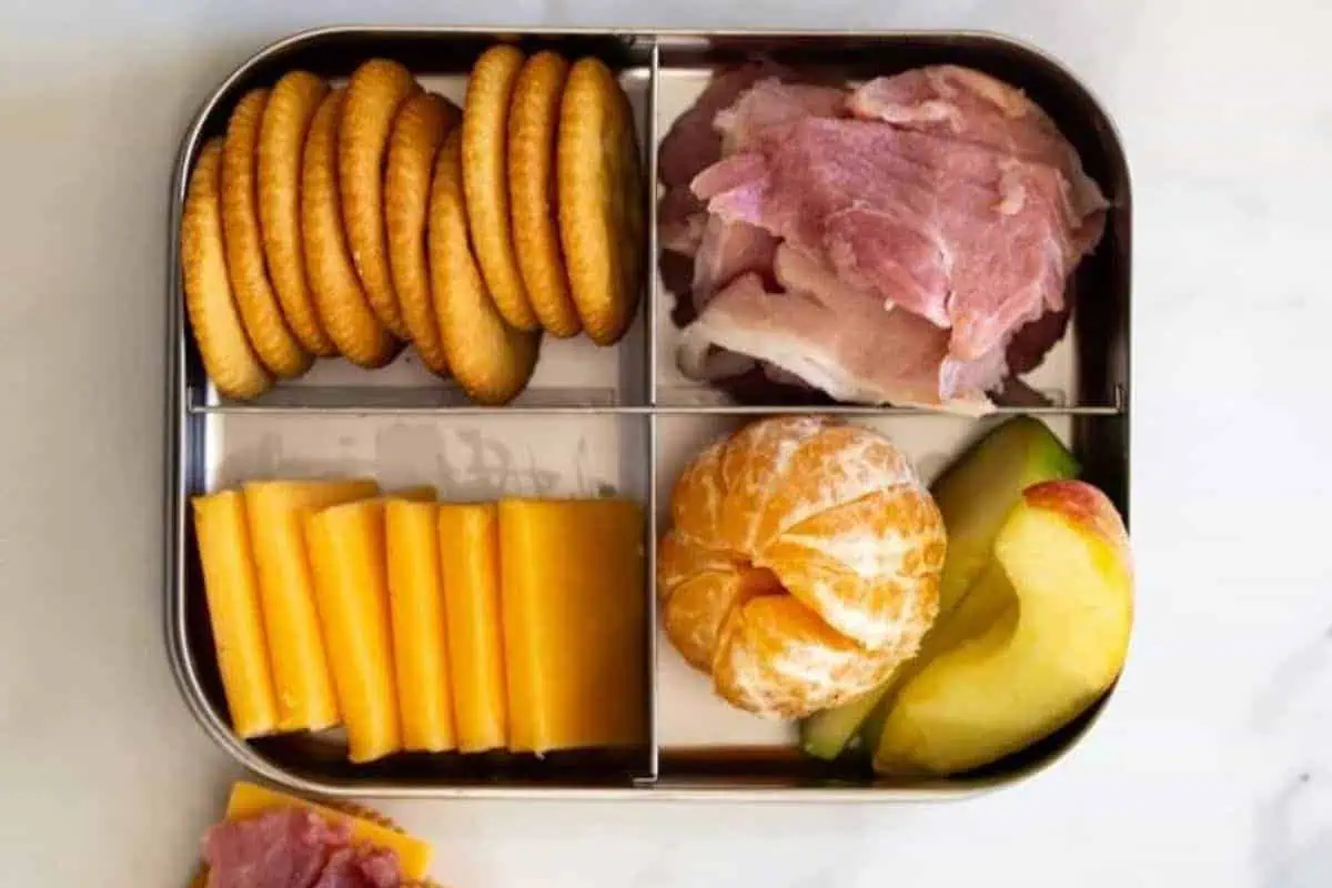 Crackers, sliced ham, and sliced cheddar cheese