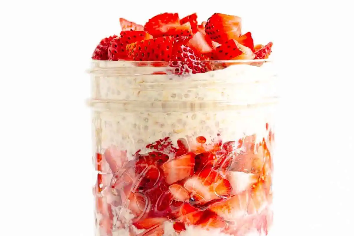 A glass jar of strawberry overnight oats.