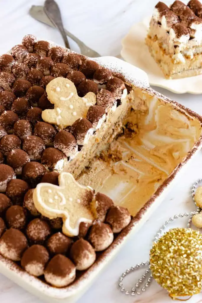 Gingerbread tiramisu in a baking dish with two slices removed.