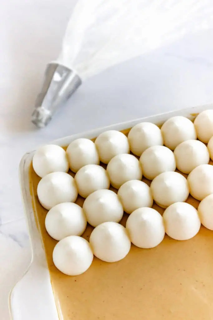 Assembled gingerbread tiramisu with piped drops of whipped cream added to the top.