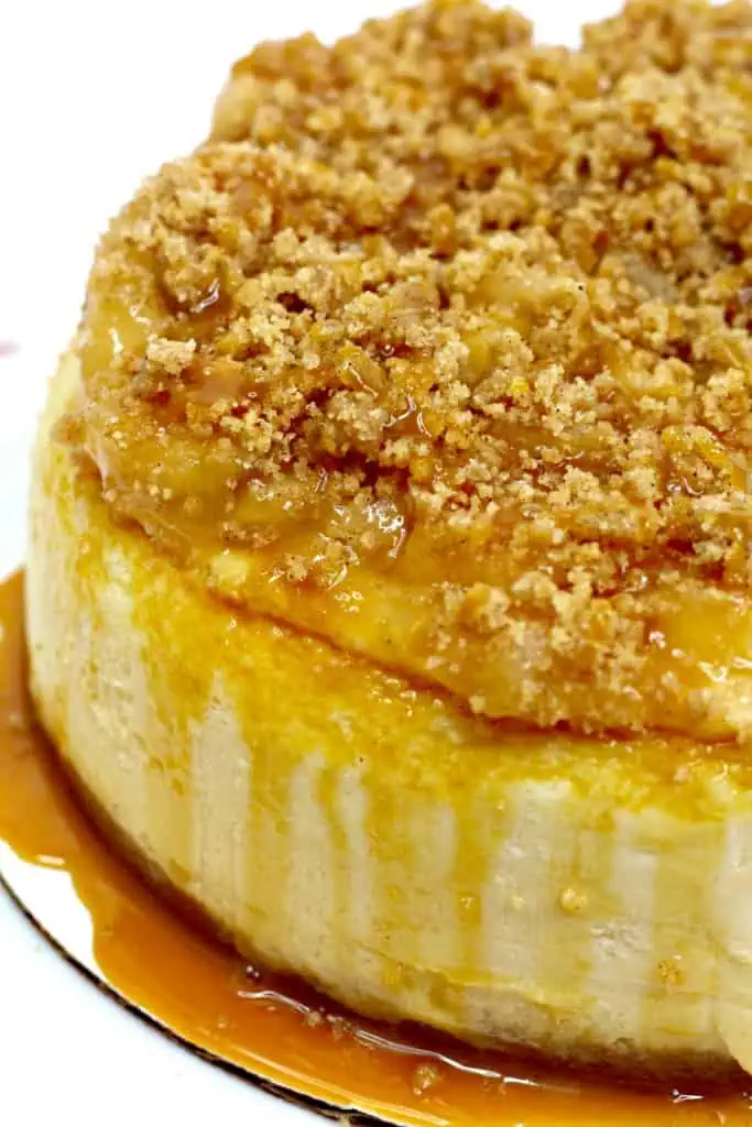 a simple shot of a cream new york style instant pot apple crumble cheesecake with a rich homemade caramel sauce