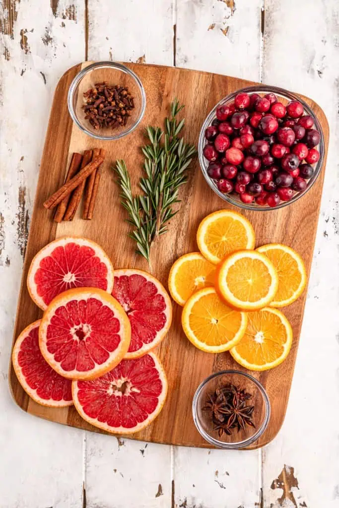 Ingredients for making Christmas simmering pot on a wooden kitchen board.