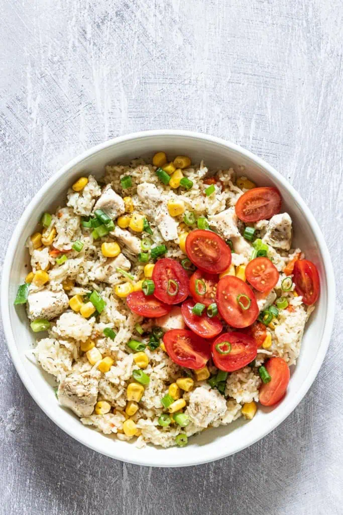 Close up of a bowl of Instant pot chicken and rice with vegetables.
