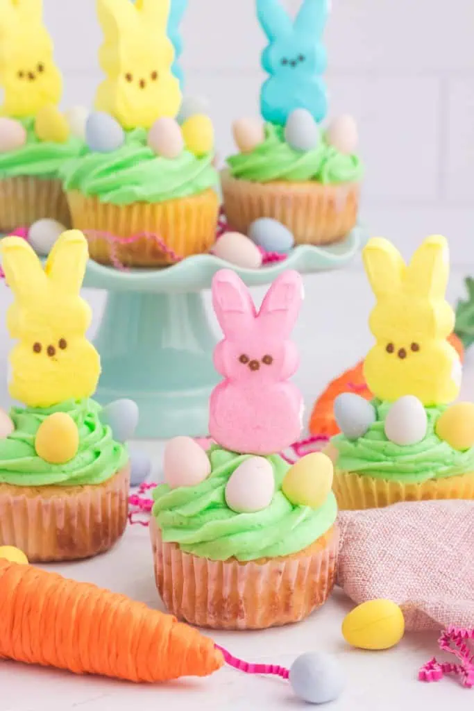 Peeps cupcakes on a marble countertop and on a cake stand.